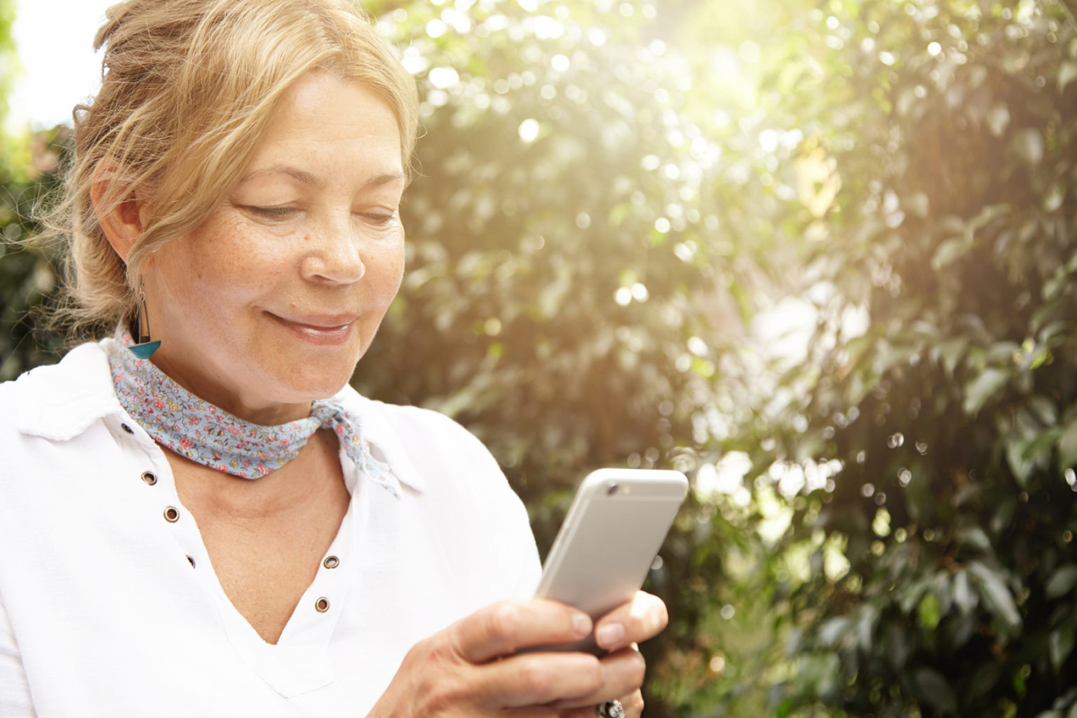 woman looking at her phone smiling