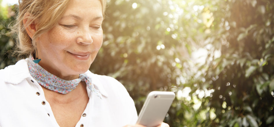 woman looking at her phone smiling