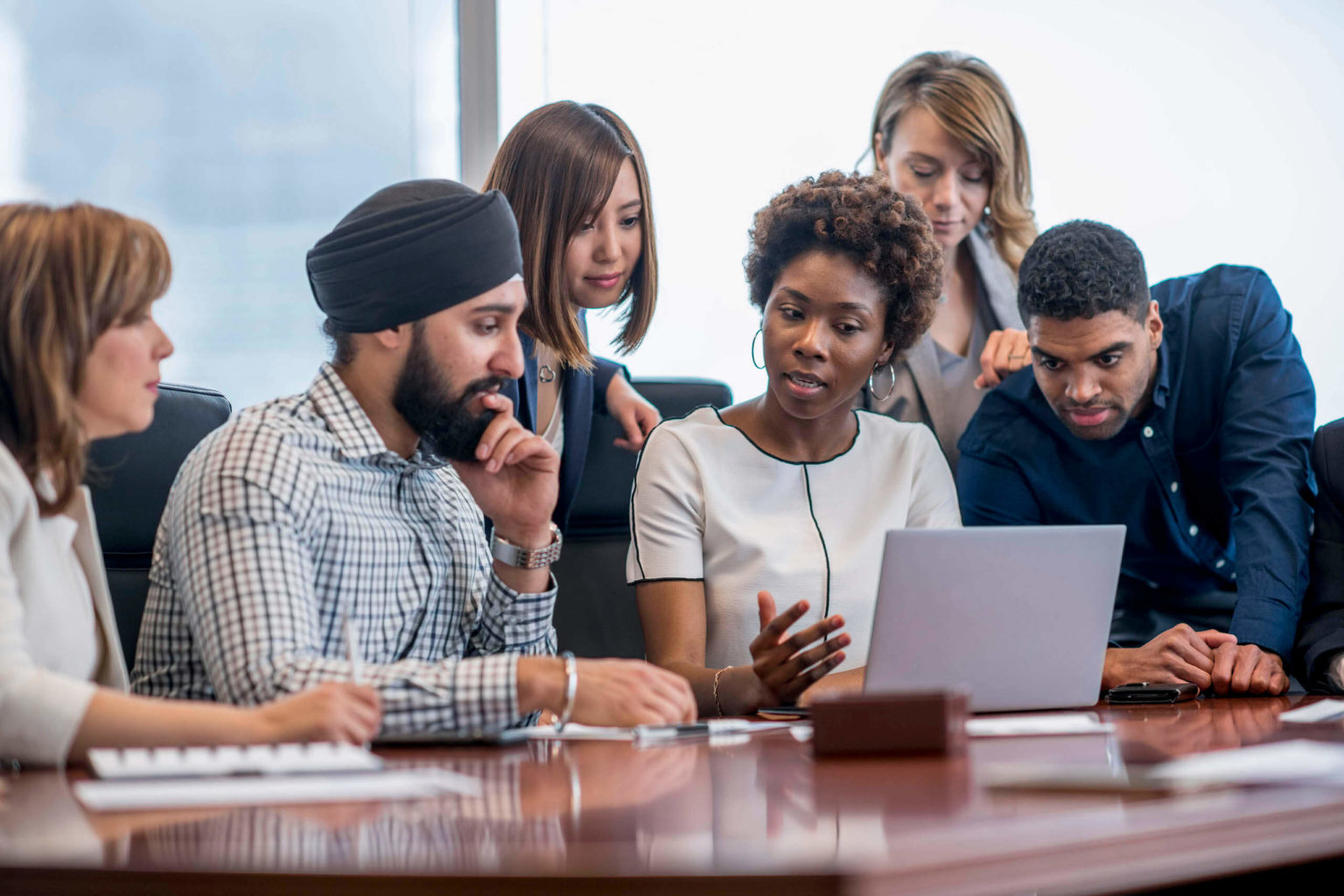 a group of people looking at a laptop